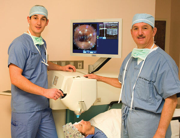 vision correction near me - Eye Doctors and Cataract Surgeons Blehm and J. Chapman standing by laser cataract surgery equipment.